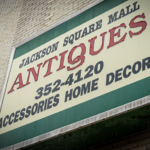 Exterior sign for Jackson Square Mall Antiques advertising accessories, home decor, and the phone number 352-4120.