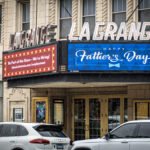 Front entrance of the LaGrange Theater with a marquee displaying "Happy Father's Day" and a hiring announcement, with cars parked along the street.